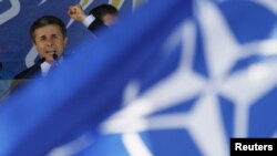 A NATO flag flutters in front of Bidzina Ivanishvili, a leader of the opposition Georgian Dream coalition, as he addresses supporters at an election rally in Tbilisi in late September.