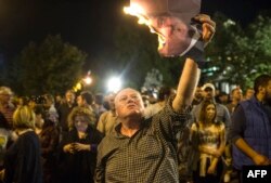 A protester burns a photo of Macedonia's president in Skopje on April 13.