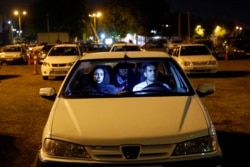 Iranians sit in their cars while taking part in a religious ceremony during the holy month of Ramadan in a parking in Tehran.