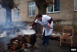 A nurse cooks on an outdoor fireplace due to the lack of gas inside the Mental Hospital N1/4 2 on the outskirts of Donetsk in December.