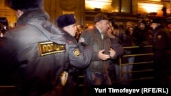 Police detain one of dozens of activists at a protest rally in central Moscow.