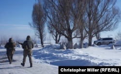 Ukrainian soldiers meet international observers from the OSCE as they enter Novoluhanske from the separatist-controlled side of the front line.