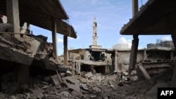 Damaged buildings and a minaret in the central Syrian town of Talbisah in Homs Province on September 30.