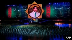 A massive portrait of Berdymukhammedov looms over attendees at an inauguration ceremony for the Palace of Happiness wedding complex in Ashgabat in October 2011.