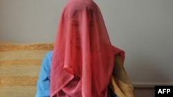 A woman who spent two years in prison for running away from an abusive husband sits for a portrait in a Kabul shelter for women.