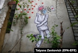 Graffiti in the Belarusian city of Brest in April last year depicting a sick person with a coronavirus on his head while wearing a protective mask.