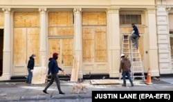 Workers put plywood over windows of stores in New York City as a precaution against potential damage from election-related protests on November 2.