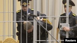 Uladzislau Kavalyou is led into a holding cage before hearings in Minsk on September 15.