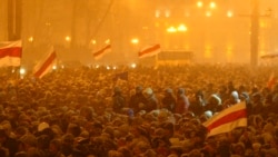 Supporters of opposition leader Alyaksandr Milinkevich gather in a square in Minsk during a heavy snow storm, with some demonstrators waving the banned Belarusian flag on March 19, 2006.