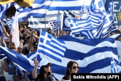 Protesters wave Greek flags as they take part in a demonstration to protest against the use of the name Macedonia in Pella on June 6.