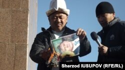 Former regional police chief Abdulla Kapparov burns a portrait of Kyrgyz President Almazbek Atambaev on Osh's central square.