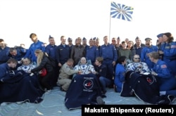 International Space Station crew members Ricky Arnold (left) and Drew Feustel (right), from the United States, and Oleg Artemyev of Russia rest in chairs after landing in a remote area outside the town of Dzhezkazgan, Kazakhstan on October 4.