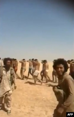 An image grab taken from a video uploaded on social networks in August shows young men dressed only in their underwear being marched along a road before allegedly being executed by Islamic State militants.