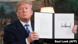 U.S. President Donald Trump signs a document reinstating sanctions against Iran after announcing Washington's withdrawal from the nuclear deal in 2015.