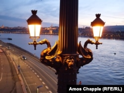 Winged dragons hold the lanterns of Budapest's Margaret Bridge at dusk.