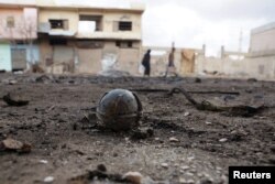 An unexploded cluster bomblet is seen along a street after air strikes by pro-Syrian forces in the rebel held town of al-Ghariyah al-Gharbiyah in Deraa Province on February 11.2016