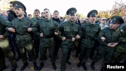 Antigay protesters dressed in cossack uniforms form a human chain as they try to prevent gay-rights activists from staging a protest in St. Petersburg.