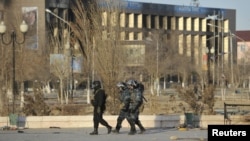 Kazakh Interior Ministry troops patrol among burnt buildings following the deadly riots in Zhanaozen late last year.