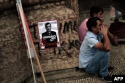 Protesters sit near a poster portraying Prime Minister Recep Tayyip Erdogan as Hitler in Istanbul on June 5.