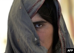 An Afghan refugee, recently returned from Pakistan, waits at a UNHCR center in Jalalabad. Tens of thousands of Afghan refugees have returned, with many claiming to have been beaten by police, detained, and evicted from their homes in Pakistan.