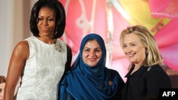 U.S. first lady Michelle Obama (left) and Secretary of State Hillary Clinton (right) pose with Shad Begum of Pakistan as she receives the 2012 International Women of Courage award in Washington.