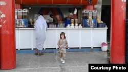 Abdrakhman in fatigues outside a Mosul juice bar