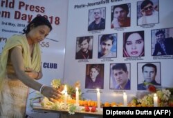 An Indian journalist lights candles during a vigil for 10 Afghan journalists who were killed in separate attacks in late April in Kabul.