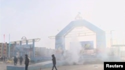 People walk past a destroyed stage in Zhanaozen in this still image taken from a video acquired by Reuters on December 16.