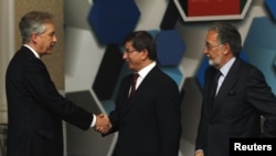 Turkish Foreign Minister Ahmet Davutoglu (center), accompanied by his Afghan counterpart Zalmay Rasul (right), shakes hands with U.S. Deputy Secretary of State William Burns before the Istanbul Conference on November 2.