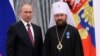 Russian President Vladimir Putin (left) awards Metropolitan Ilarion of Volokolamsk with an Order of Honor during a ceremony at the Moscow Kremlin in September 2016.