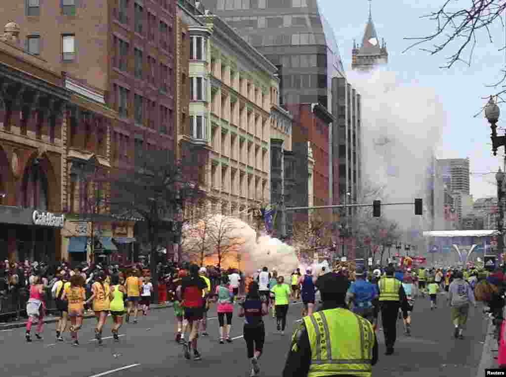 An explosion erupts as runners near the finish line.