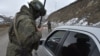 A Russian peacekeeper checks a vehicle on a road outside the town of Stepanakert on November 26, 2020, after six weeks of fighting between Armenia and Azerbaijan.