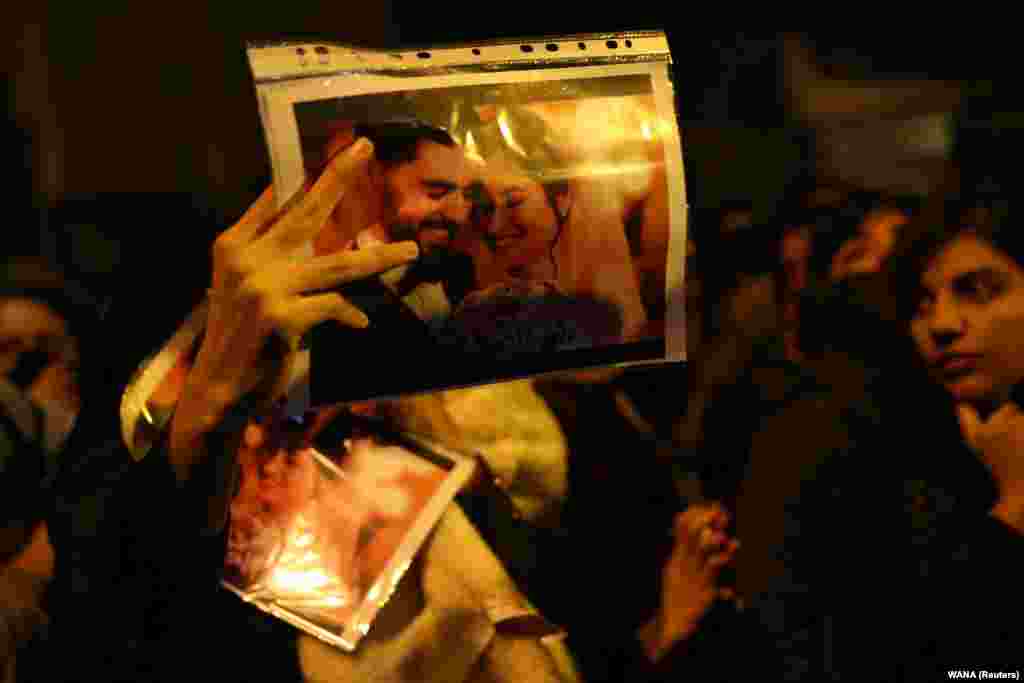 A woman holds a picture of newlyweds&nbsp;Arash Pourzarabi and Pouneh Gourji at a Tehran vigil on January 11. Both were graduate students studying computer science at the University of Alberta, and were coming back to Edmonton, Canada after celebrating their wedding in Iran.