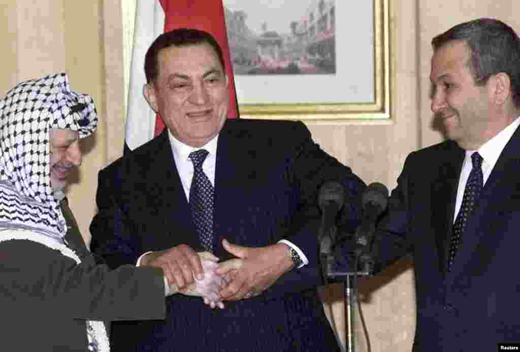 Mubarak shakes hands with Israeli Prime Minister Ehud Barak and Palestinian leader Yasser Arafat on March 9, 2000.