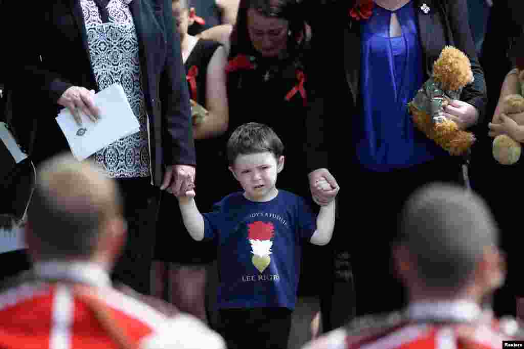 Jack Rigby watches as the coffin of his father, Fusilier Lee Rigby, is carried by members of his regiment after his funeral service at the parish church in Bury, northern England, on July 12. The soldier was murdered in London in broad daylight by Islamist extremists on May 22.&nbsp;