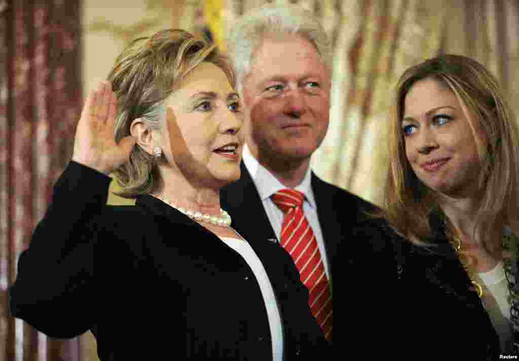 Hillary Clinton (left) is joined by her husband, former U.S. President Bill Clinton (center), and daughter, Chelsea Clinton (right), as she is ceremonially sworn in as secretary of state at the State Department in Washington on February 2, 2009.