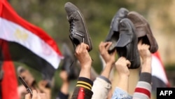 Antigovernment protesters wave their shoes outside the state television building in Cairo in February 2011 during protests that led to the ouster of President Hosni Mubarak.