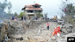 Paramedics with the Lebanese Red Cross unearth a body from the rubble at the site of an Israeli air strike that targeted the northern Lebanese village of Aito on October 14.