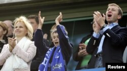 Chelsea owner Roman Abramovich (right) celebrates the team winning the English Premier League soccer trophy with his wife, Irina (left), and their son at Stamford Bridge in London in May 2007.