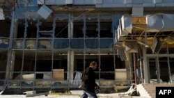 A man walks past a building damaged in recent shelling in Donetsk's Kyivskiy district near the airport on October 7. 