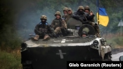 Ukrainian soldiers ride a BMP-1 infantry fighting vehicle near the recently liberated town of Izyum, on September 14.