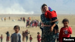 Displaced people from the minority Kurdish Yazidi sect flee forces loyal to the Islamic State in Sinjar in northern Iraq in August.