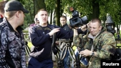 Plainclothes policemen block a cameraman as authorities suppress the "Revolution via Social Network" action in central Minsk on June 29.