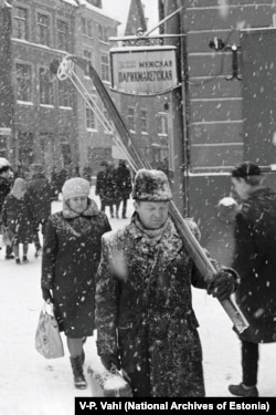 A man walks with his skis and a briefcase in Tallin in 1960.