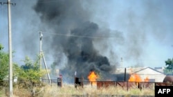 Smoke billows over a damaged building after shelling on the outskirts of the small southern Ukrainian city of Novoazovsk on August 27.