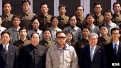 North Korean leader Kim Jong-il (in light jacket) poses with scientists and technicians at a purported satellite-control center after in April.