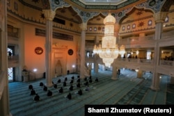 Clerics wearing face masks attend a prayer marking the Muslim festival of Eid al-Adha while maintaining social distance in Moscow's grand mosque on July 31.