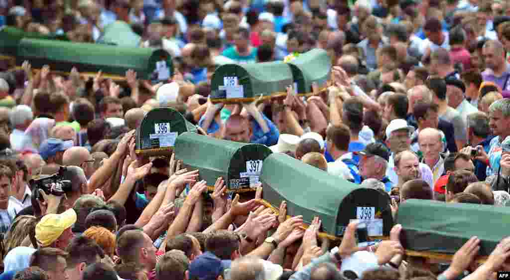 Bosnian Muslims carry caskets containing the bodies of people killed in the 1995 Srebrenica&nbsp;massacre as they prepare for a mass burial during a memorial ceremony in the village of Potocari on July 11, the 18th anniversary of the killings. (AFP/Elvis Barukcic)