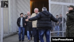 Inmates recently classified as political prisoners leave a Georgian prison on January 13.