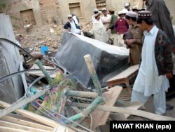 Hayatullah Khan's photo taken on December 1, 2005, shows local tribesmen inspecting the debris of a house in a village north of Mir Shah, Pakistan, that was destroyed by two alleged U.S. reconnaissance aircraft.